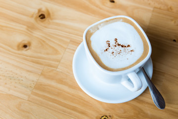 Hot cappuccino cup on wooden table top view