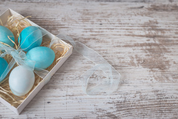 Blue Easter eggs on white old table. Concept of Easter and spring
