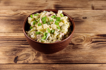 Traditional Russian festive salad Olivier on wooden table