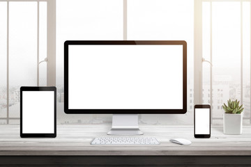 Responsive web site promotion. Isolated blank computer, tablet and smart phone display. Window and sun light in background.