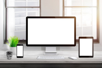 Responsive devices mockup on office desk. Isolated, blank computer display, tablet and mobile phone.
