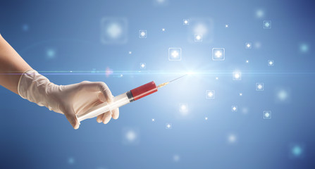 Female doctor hand holding syringe with shiny crosses in the background