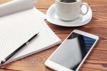 Office desk table top view. Notepad with blank pages on wooden table