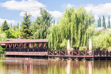 Naklejka premium Cafe bar and furniture by the lake in summer day