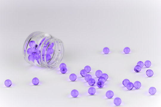 violet vitamins in a glass jar white background