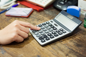 A women hand with calculator on business table.