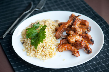 grilled pork with rib in white dish, served with bulgur