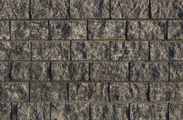 Gray wall made of granite bricks, texture, background.
