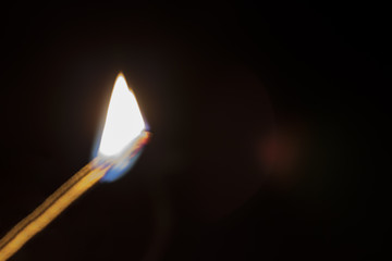 Burning match on a black background