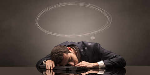 Young businessman sleeping and dreaming at the office
