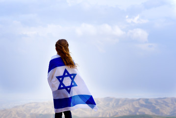 Little patriot jewish girl standing and  enjoying great view on the sky, valley and mountains with...