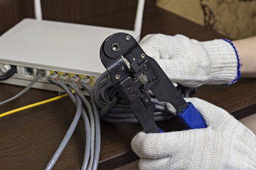 .A man is squeezing a chip on a network cable, a modem, the Internet, a close-up