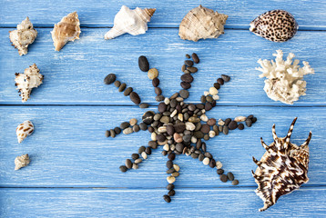 Sea shells and stones on a blue wooden background
