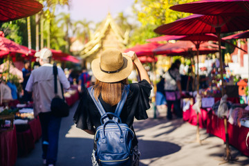 Fototapeta na wymiar Young woman traveler traveling to Wat Phra Singh temple. This temple contains supreme examples of Lanna art in the old city center of Chiang Mai,Thailand.