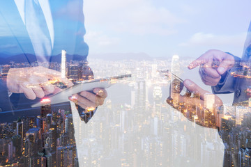 Double Exposure of a businessman use smartphone on the Hong Kong skyscraper background.