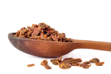 Propolis granules in a wooden spoon. Bee glue. Bee products. Apitherapy.