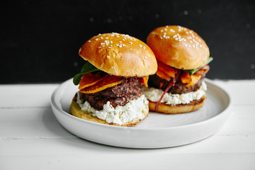 Burgers with grilled beef patties, cream cheese and spinach on classical bun.