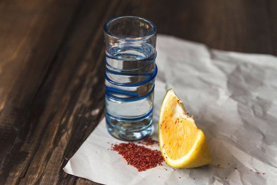 Traditional Mexican Mezcal From Oaxaca On A Shot Glass With An Orange Slice And Chili