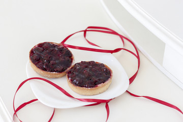 Два ягодных пирожных лежат на белой тарелке