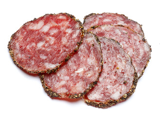 Dried organic salami sausage covered with pepper on white background