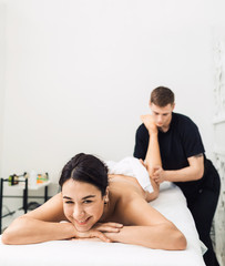 Obraz na płótnie Canvas man is doing massage foots to beautiful young woman at spa. Concept of healthy lifestyle. Copy space.