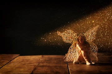 image of magical little fairy sitting on old wooden floor.