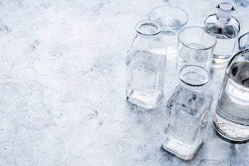Drinks on the table. Pure water in jar and glasses on grey background space for text