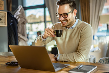 Young handsome man enjoy coffee working on laptop