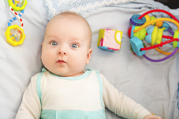child 3 months old lies alone in bed