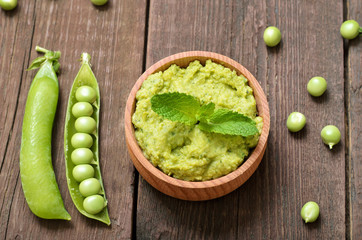 Green pea puree in wooden bowl