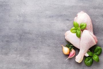 Chicken legs, fresh spice on a gray background.Top view.