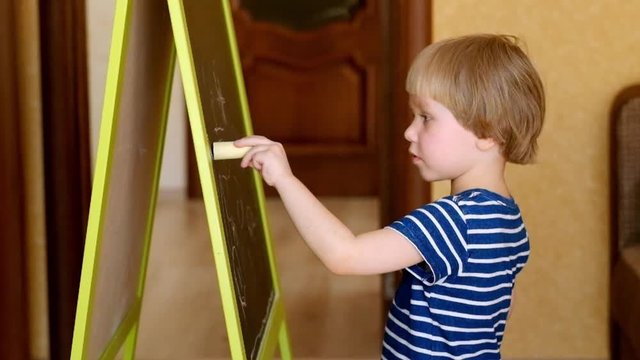 Toddler drawing at the blackboard