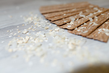 Close-up of dietary loaves laid out in the form of a fan on each other on a wooden table in rice flakes. Dry snacks dietary breakfasts, loaves on a grey wooden table.