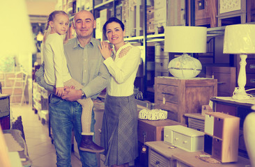 married couple with daughter in  furniture store