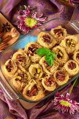 Egyptian dessert Kunafa made of kataifi dough with pistachio and pecan nuts in a glass baking dish....