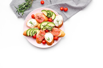 Healthy lunch with mini sandwiches cheese, fish and avocado on white background top view space for text