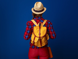 active tourist woman with backpack isolated on blue