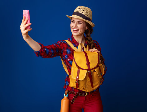 happy fit tourist woman taking selfie with mobile phone