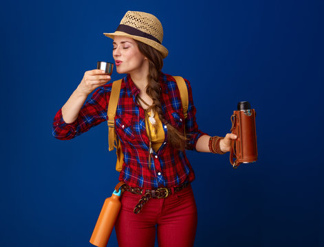 tourist woman drinking hot beverage from thermos bottle