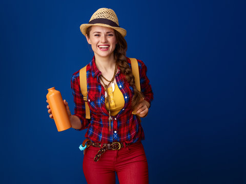 woman hiker isolated on blue background with water bottle