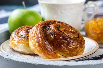 Breakfast served with green tea, orange jam and buns