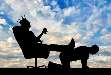 Silhouette of a selfish man with a crown on his head sitting in an armchair, threw back his legs on...