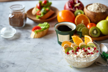 Breakfast still life with oatmeal porridge, fruits and coffee cup, top view, selective focus, shallow depth of field.