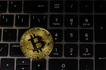 Golden bitcoin on laptop keyboard