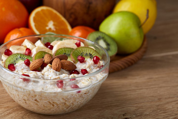 Breakfast still life with oatmeal porridge and fruits, top view, selective focus, shallow depth of field.