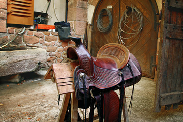 An old saddle for a horse on a farm, in a stable
