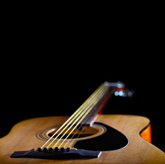 Acoustic yellow guitar on black background