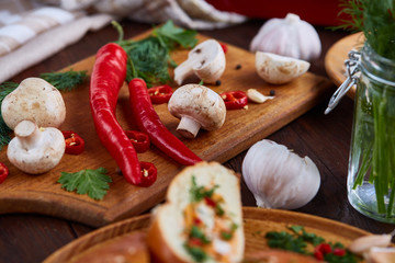 Vegetables on cutting board, plate with salt over white textured background, close-up, selective focus.