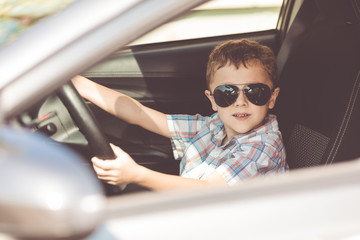 One happy little boy sitting in the car.