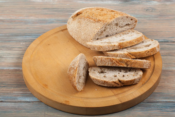 Many mixed breads and rolls of baked bread on wooden table background.